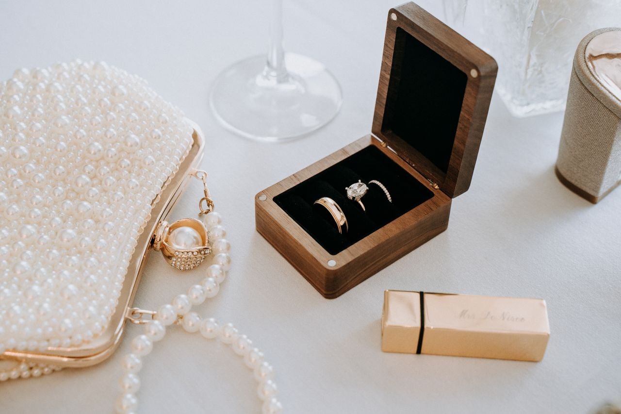 Chic flat lay of pearl accessories and wedding rings in a luxurious setting, ideal for bridal themes.