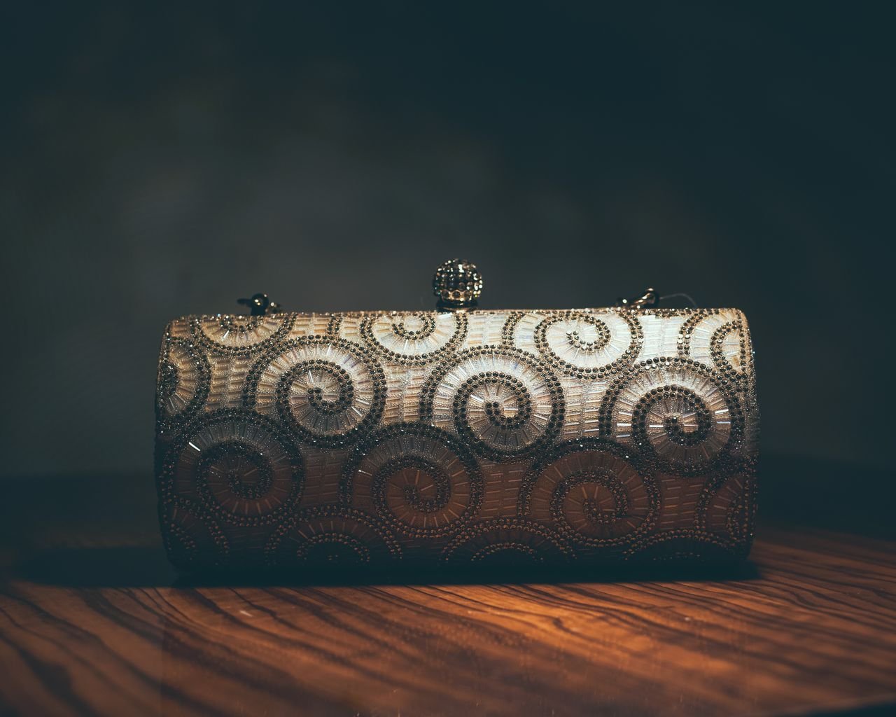 A luxurious beaded clutch purse featuring an intricate swirl pattern, perfect for evening events.